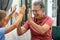 Cheerful caucasian grandfather giving high five to grandson while sitting on sofa in living room