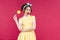 Cheerful charming pinup girl with yellow lollipop standing and w