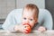 Cheerful child eating red apple  vitamins. Close up portrait of happy boy in chair