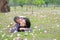 Cheerful child girl cuddle her mom lying on green field with fully fall pink flower in the garden outdoor. Happy loving family