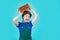 Cheerful child laborer using building uniform and brick, building