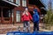 Cheerful children in jackets and hats stand near the big house and shout loudly holding hands in the spring