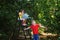 Cheerful children play in the garden with a watering can