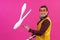 Cheerful circus performer skillfully juggling a number of clubs isolated on pink background