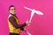 Cheerful circus performer skillfully juggling a number of clubs isolated on pink background