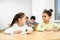 Cheerful classmates sitting at table in classroom at school