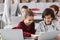 cheerful classmates typing on laptop near