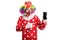 Cheerful clown holding a mobile phone and pointing at it