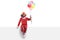 Cheerful clown sitting on a white banner and holding a bunch of balloons