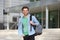 Cheerful college student standing outside with back