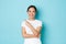 Cheerful confident asian girl in white t-shirt, pointing finger upper left corner and smiling delighted, showing way