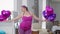 Cheerful confident plus-size woman dancing with balloons at home looking at camera smiling. Portrait of joyful Caucasian