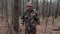 Cheerful correspondent reporter tells something to camera in forest. Hunter ranger dressed in a camouflage suit. Man