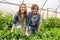 Cheerful couple of agriculturists posing for the camera in a greenhouse