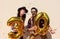 Cheerful couple celebrates a thirty years birthday with big golden balloons