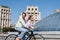 Cheerful couple cycling near building on