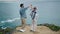 Cheerful couple dancing ocean view. Man lifting attractive woman on sea shore.