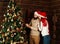 Cheerful couple decorates a Christmas tree in country house