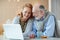 Cheerful Couple of Grandparents Using Modern Laptop