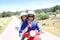 Cheerful couple on red moto visiting island