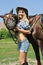 Cheerful cowgirl and her horse smiling to photographer