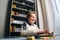 cheerful crazy child boy typing on laptop keyboard sitting at desk near window at home