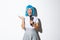Cheerful cute asian girl dressed up as anime character for halloween party, wearing blue wig and schoolgirl costume