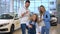 Cheerful cute girl dancing in car dealership looking at camera as blurred parents smiling talking at background