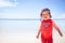 Cheerful cute happy smiling baby kid sun protective suit beach blue sea sky sunscreen background copy space