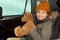 Cheerful cute little girl in warm winterwear holding soft brown teddybear