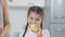 Cheerful cute Middle Eastern girl putting lemon in blender helping mother preparing healthful smoothie. Portrait of