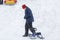 Cheerful cute young boy in orange hat and blue jacket holds tube on snow, has fun, smiles. Teenager on sledding in winter park