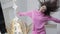 Cheerful dance of excited Caucasian slim beautiful young woman in pink hoodie in shop. Front view medium shot of happy
