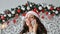 Cheerful dark curly woman wearing santa hat with exited face expression talking on phone, smiling sincerely, copy space