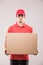 Cheerful delivery man happy young courier holding a cardboard box and smiling