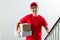 Cheerful delivery man with parcel post boxes