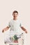 Cheerful disabled boy with Down syndrome smiling at camera while holding a recycling bin full of paper waste, standing