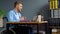 Cheerful disabled person talking on video chat while sitting at office in a wheelchair