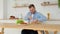 Cheerful disabled person in a wheelchair cuts bread in the kitchen