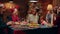 Cheerful diverse women talking at Christmas dinner table while enjoying traditional food