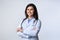 Cheerful doctor standing crossing hands in studio