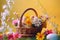 Cheerful Easter eggs and spring flowers arranged on rustic wooden backdrop