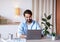 Cheerful Eastern Man Sitting At Desk In Home Office, Working On Laptop