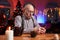 Cheerful elder man using a mobile phone sitting at table in room