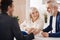 Cheerful elderly couple discussing contract at home