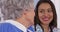 Cheerful elderly patient smiling with Mexican caregiver