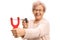 Cheerful elderly woman aiming with a slingshot and a rock