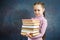 Cheerful Elementary Schoolgirl Hold Book Bunch