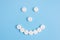 Cheerful emoticon from medical pills on a blue background