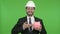 Cheerful Engineer holding Piggy Bank against Chroma Key